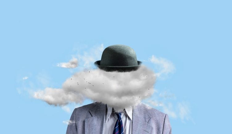 Concept photo of a person in a business suit with a cloud instead of a face against a blue background.
